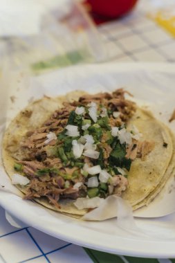 Kuzu barbacoa taco, mısır tortillası üzerine servis edilir, yanında soğan ve kişniş, geleneksel Meksika yemeği..