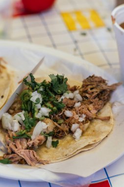 Kuzu barbacoa taco, mısır tortillası üzerine servis edilir, yanında soğan ve kişniş, geleneksel Meksika yemeği..