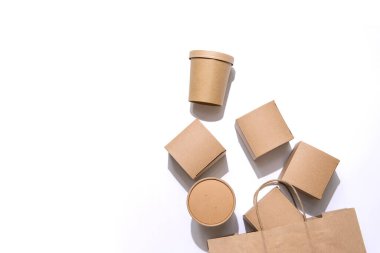 Yiyecek, içecek ve eşyalar için karton kaplar el çantasından düşüyor. Beyaz arkaplanda izole edilmiş, üst manzara. Uzayı kopyala Teslimat, paket yemek, çevre dostu paket konsepti. Kimse..