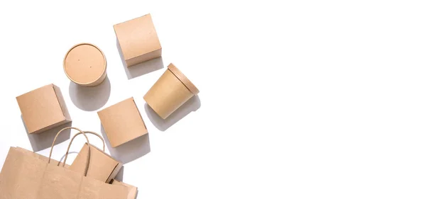 Yiyecek, içecek ve eşyalar için karton kaplar el çantasından düşüyor. Beyaz arkaplanda izole edilmiş, üst manzara. Uzayı kopyala Teslimat, paket yemek, çevre dostu paket konsepti. Kimse..