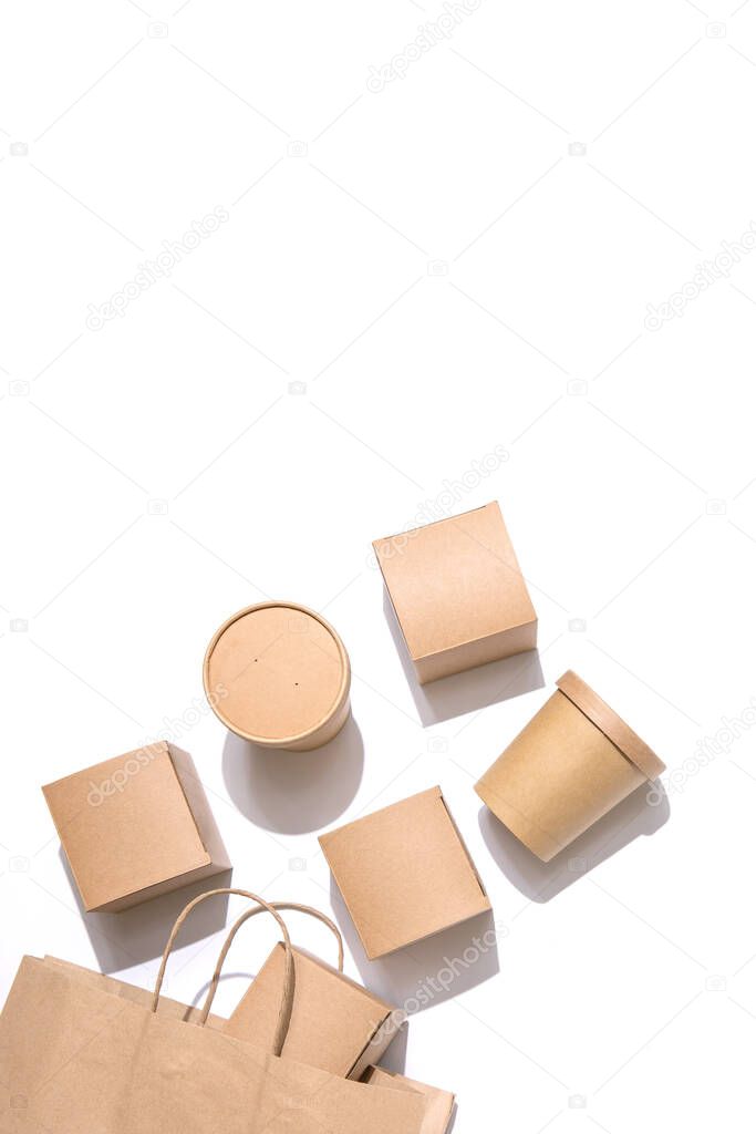 Cardboard containers and a bag for food, drinks and objects. White background. Isolate Top view. Copy space. Delivery concept, takeaway, craft packaging.Vertical
