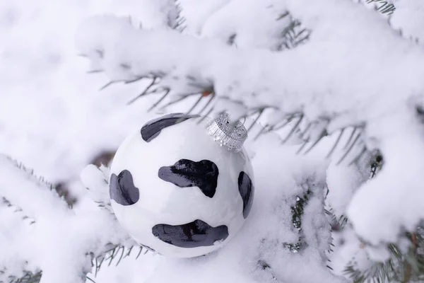 雄牛のような模様のクリスマスツリーのおもちゃは 中国の旧正月 2021のシンボルです 外側のモミの枝の真の雪の下のボール 本物の冬だ 雪のぼかしで選択的フォーカス — ストック写真