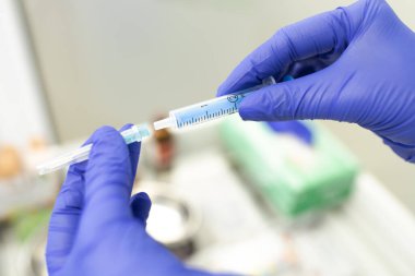 Bir hemşire ya da kadın doktorun elinde şırınga var. Corona virüsü tedavisi, aşı, enjeksiyon konsepti. Seçici odak.