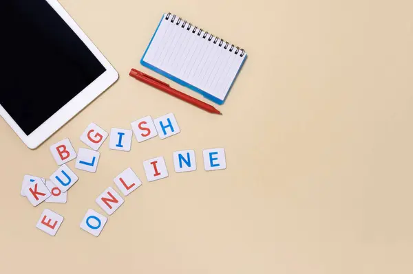 Concept of studying English online, internet courses, distance learning of foreign language. Horizontal banner with tablet, notebook, pen, inscription \