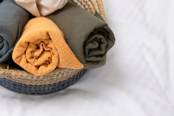 Konforlu ev için modern dekorasyon, doğal kumaşlar, doğal malzemelerden yapılan güzel şeyler. Çarşafları sepete sardım. Hiç kimse. Yatay olarak. Spa, ev dekorasyonu, bebek bakımı, eşya depolama konsepti..