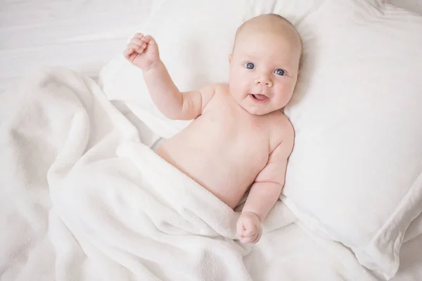 Olumlu Bir Ifadeyle Çıplak Yeni Doğmuş Bebek Yatakta Beyaz Bir — Stok fotoğraf