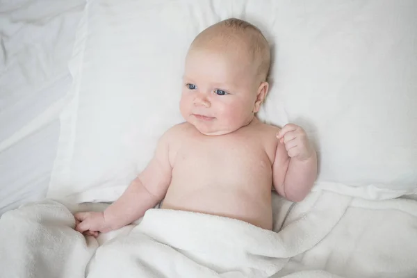 Bebê Recém Nascido Com Uma Expressão Engraçada Positiva Deita Cama — Fotografia de Stock