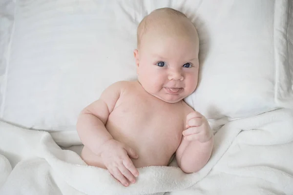 Bebê Recém Nascido Com Uma Expressão Engraçada Positiva Deita Cama — Fotografia de Stock