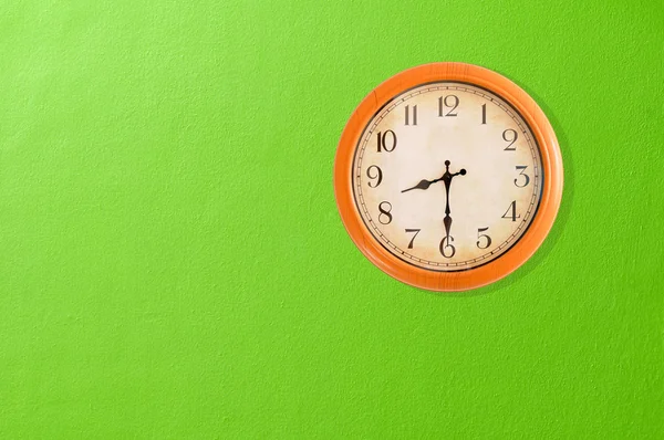 Ρολόι που παρουσιάζει σε έναν πράσινο τοίχο — Φωτογραφία Αρχείου