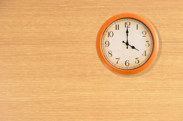 Relógio mostrando 4 horas em uma parede de madeira — Fotografia de Stock