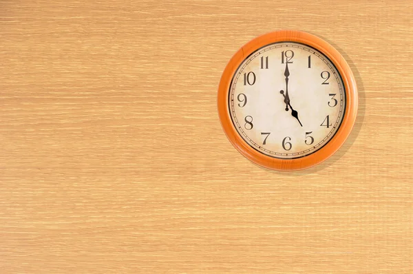 Relógio mostrando 5 horas em uma parede de madeira — Fotografia de Stock