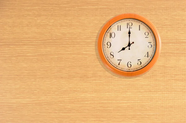 Relógio mostrando 8 horas em uma parede de madeira — Fotografia de Stock