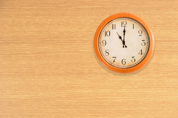 Relógio mostrando 11 horas em uma parede de madeira — Fotografia de Stock