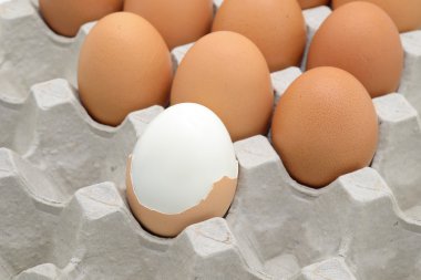 Haşlanmış yumurta ve kağıt sandık üzerinde çiğ yumurta