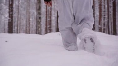 Erkek ayakları derin karda yürüyor. Yürüyüşçülerin ayak izleri. Avcı ormanda yürür.