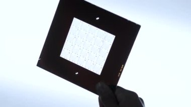 Elektrikli devre düzenini elinde tutan bir teknisyen. Yazılı devre kartları için fotoğraf maskesi