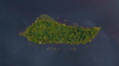Güneşli bir günde göldeki küçük bir adanın havadan görünüşü. Alışılmadık doğa olayları