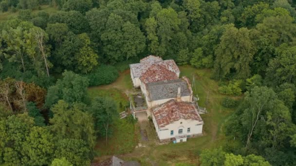 Weißrussland. Verlassener Palast, Herrenhaus oder Herrenhaus mit kaputten Fenstern. Alter verlassener Palast in einem dichten grünen Wald. Rundumblick aus der Luft. — Stockvideo