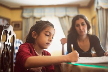 Anne ve kızı ödev yapıyor.