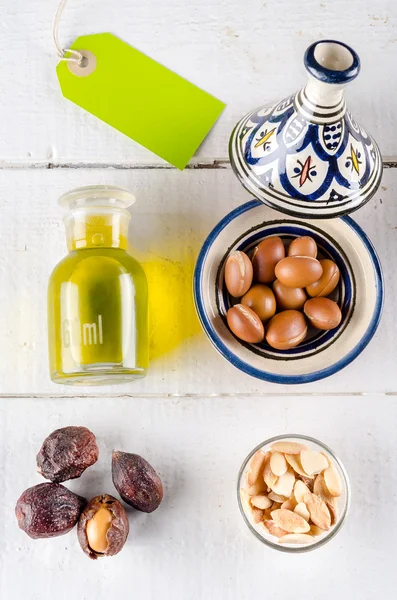 Frutos secos de argán y aceite en la mesa — Foto de Stock