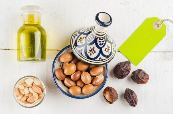 Argan nuts and oil on tabletop — Stock Photo, Image