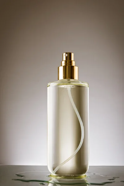 Bottiglia di profumo su superficie riflettente — Foto Stock