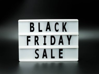 Kara Cuma indirimli sözcüğü siyah arka planda ışık kutusu üzerine