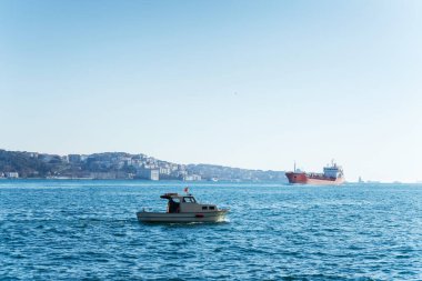 İstanbul Boğazı 'nda küçük bir tekne denize açılıyor. Ortakoy bölgesinden İstanbul Boğazı manzarası