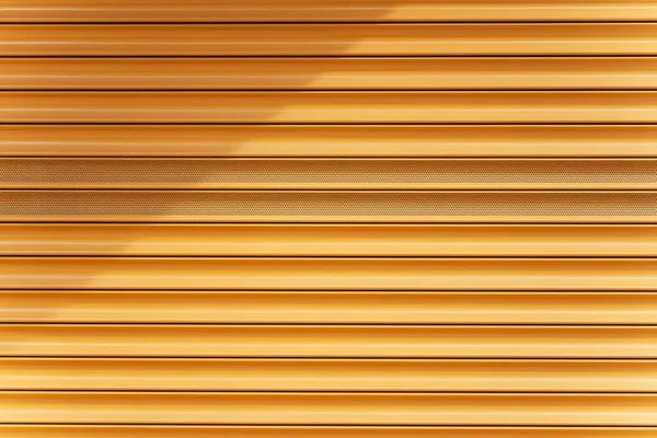 Yellow metal roll door close-up. Yellow plank texture