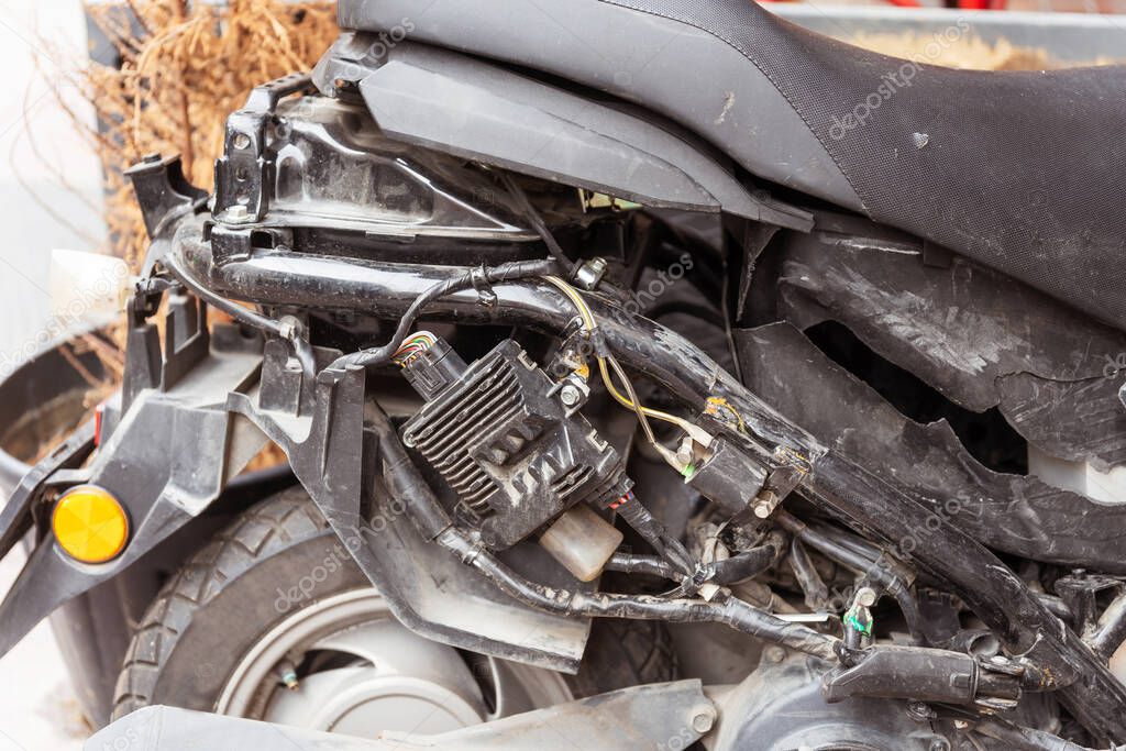 Broken moto scooter primer plano. Se trapeó después del accidente. Plástico roto y mecanismos