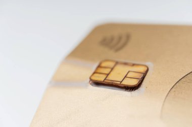 Bozuk bir banka kartı ve mikroçip. Temassız ödemesi olan hasarlı bir banka kartı. Altın karttan alınmış bir mikroçip.