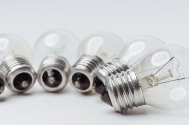 Beyaz arka planda yanıp sönen parlak ampuller. Yakın plan avize için kırık ampuller. Eskimiş, modası geçmiş, parlak ampuller.