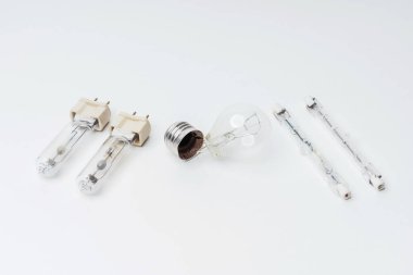 Beyaz arka planda yanıp sönen parlak ampuller. Yakın plan avize için kırık ampuller. Eskimiş, modası geçmiş, parlak ampuller.