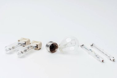 Beyaz arka planda yanıp sönen parlak ampuller. Yakın plan avize için kırık ampuller. Eskimiş, modası geçmiş, parlak ampuller.