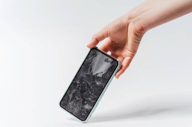 Beyaz arka planda kırık ekranı olan bir akıllı telefon. Akıllı telefon için koruyucu camı kırın. Kırık ekranlı pahalı bir akıllı telefon.