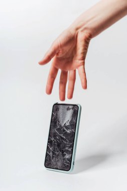 Beyaz arka planda akıllı telefonun elinden düşmesi. Akıllı telefon için koruyucu camı kırın. Bozuk ekranlı akıllı telefon kontrolden çıktı.