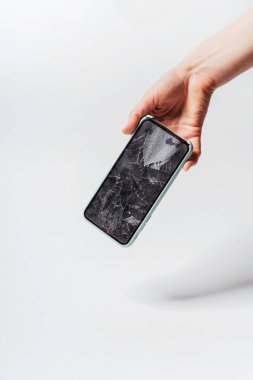 Beyaz arka planda kırık ekranı olan bir akıllı telefon. Akıllı telefon için koruyucu camı kırın. Kırık ekranlı pahalı bir akıllı telefon.