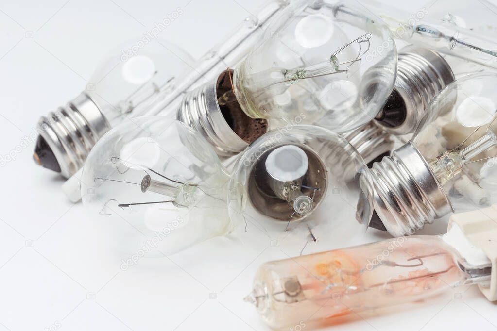 Burnt-out incandescent light bulbs on a white background. Broken light bulbs for a chandelier close-up. Vintage old outdated Incandescent light bulbs