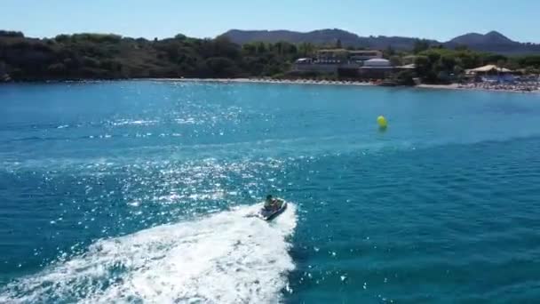 Vista aérea de un barco de motos acuáticas en un mar de color azul profundo, Zakynthos, Grecia — Vídeos de Stock