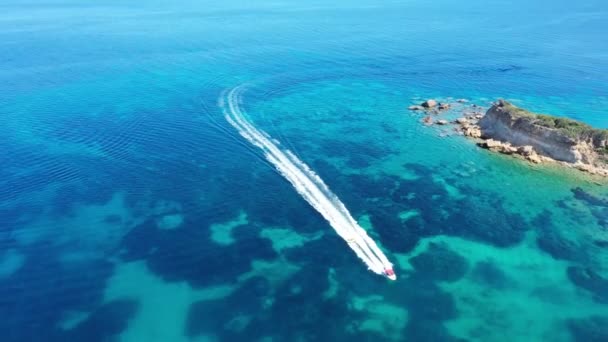 Vista aérea de um barco a motor rebocando um tubo. Zakynthos, Grécia — Vídeo de Stock
