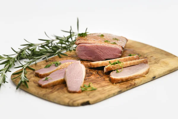 Smoked duck sliced with herbs on a wooden background. — Stock Photo, Image