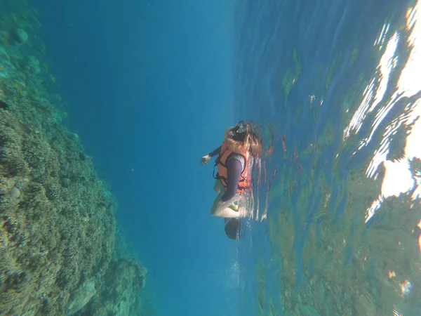 Silhueta de mergulhador e luz solar na água azul — Fotografia de Stock
