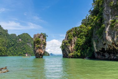 Tayland 'daki turkuaz yeşil sulardan dramatik kireç taşı oluşumları yükseliyor. Uçurumları olan tropik deniz manzarası, yemyeşil bitki örtüsü ve egzotik doğa, popüler seyahat ve macera mekanı..