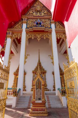 Geleneksel Tayland tapınağının şaşaalı bir görüntüsü zarif mimarisi ve ziyaretçileri etkileyen canlı renkleri var.