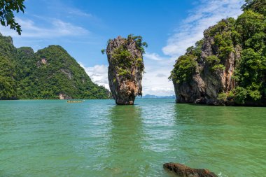 Tayland 'daki turkuaz yeşil sulardan dramatik kireç taşı oluşumları yükseliyor. Uçurumları olan tropik deniz manzarası, yemyeşil bitki örtüsü ve egzotik doğa, popüler seyahat ve macera mekanı..