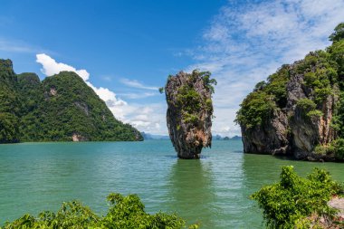 Tayland 'daki turkuaz yeşil sulardan dramatik kireç taşı oluşumları yükseliyor. Uçurumları olan tropik deniz manzarası, yemyeşil bitki örtüsü ve egzotik doğa, popüler seyahat ve macera mekanı..
