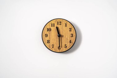 Beyaz zemin üzerinde beyaz kadranlı ahşap ofis duvar saati. Beyaz arkaplanda duvar saati, en üst görünüm.