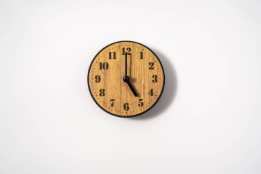 Beyaz zemin üzerinde beyaz kadranlı ahşap ofis duvar saati. Beyaz arkaplanda duvar saati, en üst görünüm.