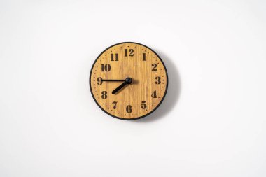 Beyaz zemin üzerinde beyaz kadranlı ahşap ofis duvar saati. Beyaz arkaplanda duvar saati, en üst görünüm.