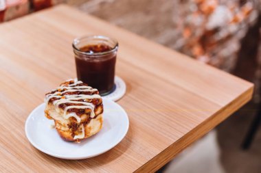 Bir tabak tarçınlı çörek ve bir fincan sade kahve.